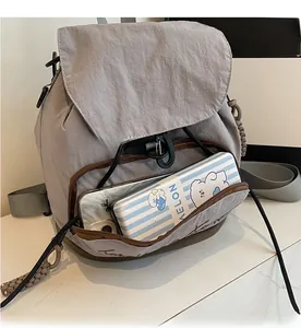 Vue détaillée de la poche avant du sac à dos en toile montrant le rangement du mobile