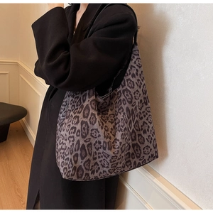 Detail shot of a large leopard print tote bag with soft texture worn on shoulder