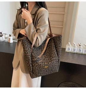 Detail of leopard print tote bag with a golden handmade tag on a casual scene