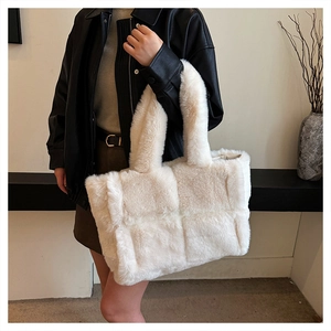 Détail d'un sac cabas en fausse fourrure pelucheuse avec texture tissée porté par un mannequin