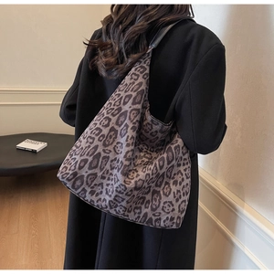 Detail of large leopard print faux fur tote bag showing soft texture and wide shoulder strap