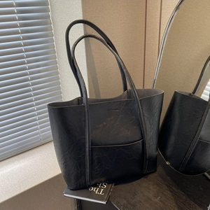 Minimalist black PU leather tote bag with front pocket and textured finish for women