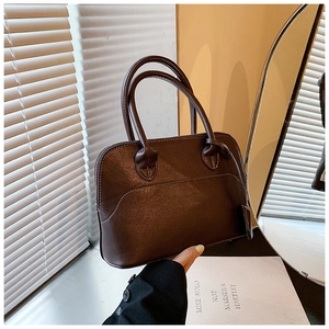 Dark brown leather shoulder bag with white contrast stitching and curved top handle