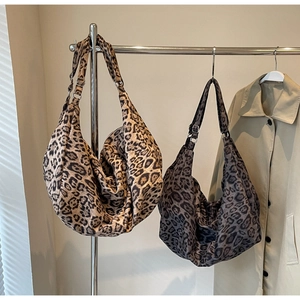 Detail view of two large leopard print canvas hobo bags in brown and grey tones