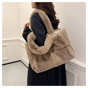 Détail d'un sac cabas en fausse fourrure marron avec motif losange et doublure en satin
