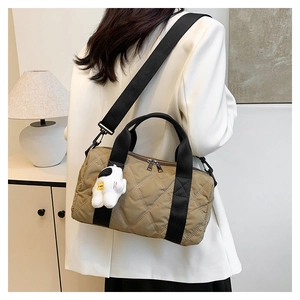Detailed quilted nylon barrel bag with astronaut charm and wide crossbody strap