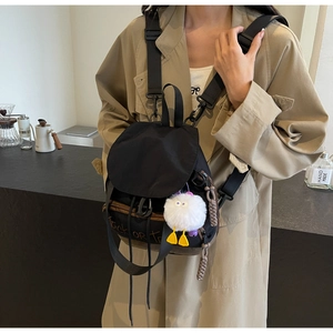 Détail du mini sac à dos en nylon noir avec texte orange Trick or Treat et pompon en peluche