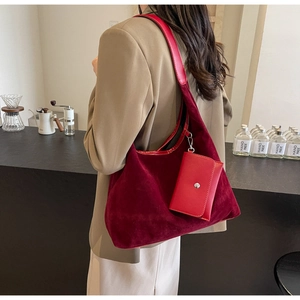 Detail of burgundy velvet tote bag and matching pouch showing texture and leather strap