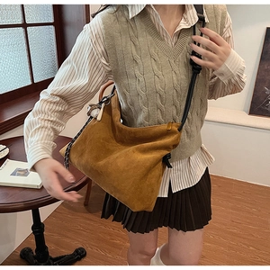 Détail du sac bandoulière en suède avec bandoulière tressée dans un décor de style de vie