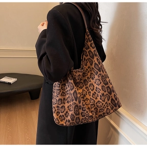 Detail shot of a large leopard print tote bag with a faux suede finish and shoulder strap