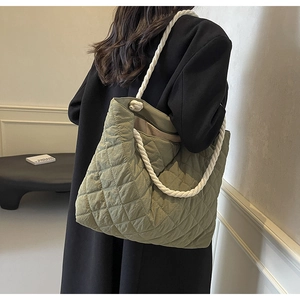 Detail of sage green quilted tote bag with chunky white cotton rope handles