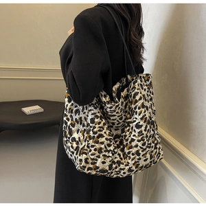 Detail of leopard print quilted tote bag with diamond stitching and black handles