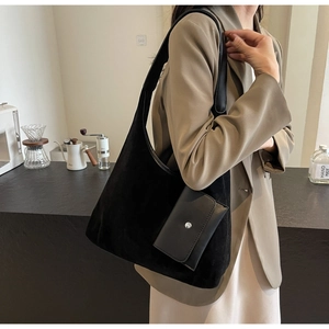 Detail of minimalist black oversized suede tote bag with a small detachable coin purse