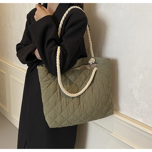Detail of olive green quilted tote bag with chunky white cotton rope handle and knot