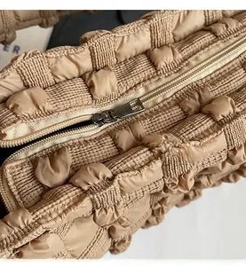 Détail de la texture en tissu popcorn kaki avec fermeture à glissière en métal sur le sac