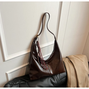 Deep brown glossy PU leather hobo shoulder bag with a woven tassel charm in autumn style