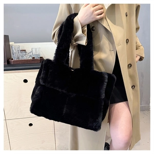 Détail d'un sac à bandoulière en fausse fourrure noire porté par un mannequin en automne