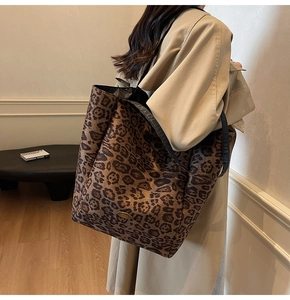 Close-up of leopard print tote bag with metallic logo detail and sleek shoulder strap