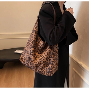 Detail of trendy leopard print tote bag with premium leather straps on a model