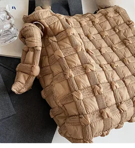 Vue détaillée de la texture matelassée et du design bouffant du sac à main kaki