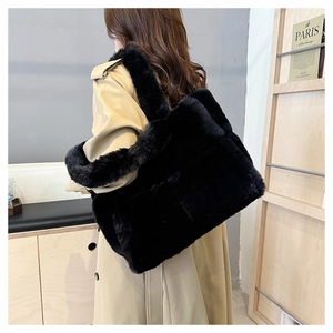 Sac fourre-tout tendance en fausse fourrure noire porté avec un trench beige pour l'hiver