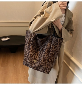 Detail shot of leopard print velvet tote bag with gold metal logo and sturdy texture
