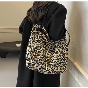 Detail of leopard print quilted tote bag with diamond stitching and black straps
