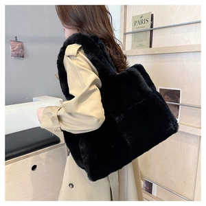 Détail du sac cabas noir en fausse fourrure montrant la texture douce sur un mannequin