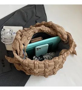 Détail de l'intérieur du sac matelassé marron avec doublure rayée et grand volume