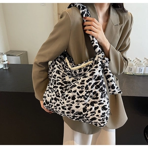 Close-up of quilted leopard print tote bag with bow detail on a stylish shoulder strap