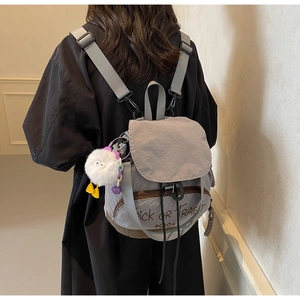 Détail du sac à dos en toile grise avec imprimé Trick or Treat et pendentif poussin doux