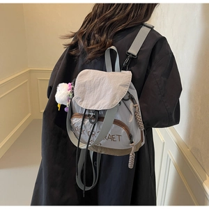 Détail d'un sac à dos en nylon gris avec imprimé Trick or Treat et charm en peluche