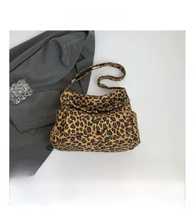 Detail view of leopard print crossbody bag with functional front zip pocket and strap