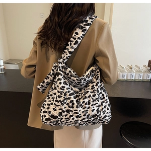 Detail of a large quilted shoulder bag with black and white leopard print and wide strap