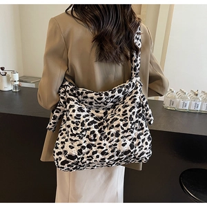 Quilted leopard print tote bag worn with a stylish blazer in a minimalist cafe setting