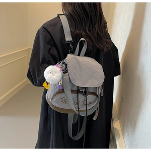 Détail d'un sac à dos en nylon gris avec imprimé Trick or Treat et breloque monstre