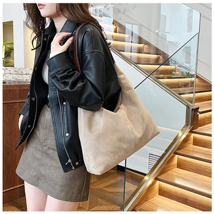Chic beige frosted PU leather tote bag styled with casual urban outfit on stairs