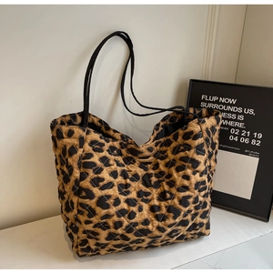Modern leopard print quilted tote bag with black handles on a minimalist background