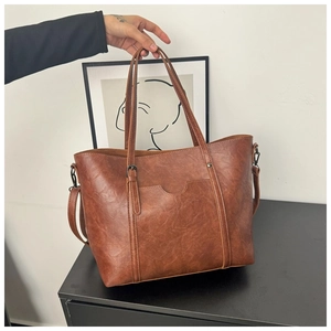 Détails de la texture du cuir huilé marron vintage et des poches du grand sac cabas fourre-tout