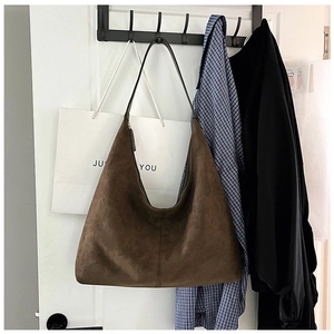 Close-up of deep brown matte suede tote bag with delicate texture and slim leather strap