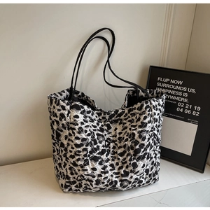 Quilted tote bag featuring black and white leopard print and slim black shoulder straps