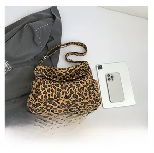 Detailed view of leopard print canvas bag with two front pockets and adjustable strap