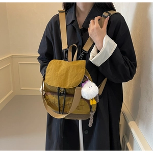Gros plan du sac à dos en tissu jaune moutarde avec motif Trick or Treat et pompon