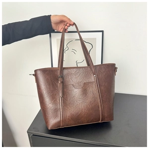 Détail du sac cabas en cuir marron vintage avec sangles verticales et poche frontale