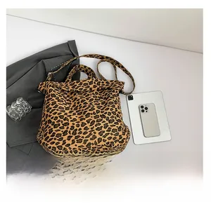 Leopard print canvas tote bag shown with tablet and phone to demonstrate large capacity