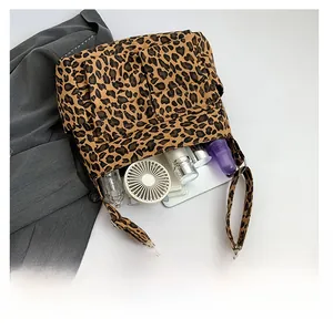 Detail view of spacious leopard print tote bag interior holding daily essentials and gadgets