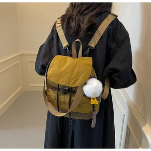 Détail du sac à dos en nylon jaune gingembre avec lettrage Trick or Treat et charm en peluche