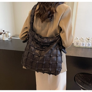 Vue arrière du sac cabas matelassé noir avec bandoulière nouée porté par un mannequin