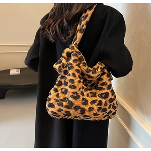 Close-up of leopard print quilted tote bag in nylon fabric on black coat shoulder