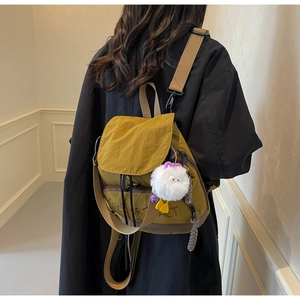 Détails du sac à dos en nylon jaune moutarde avec fermeture à cordon et lettrage stylé